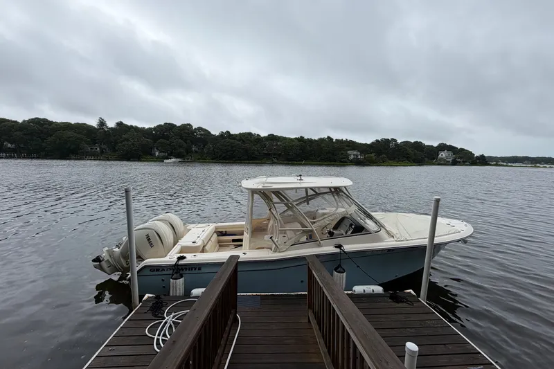 The Image of 2025 Grady-White Freedom 275 boat docked on a serene lake under cloudy skies. - 0