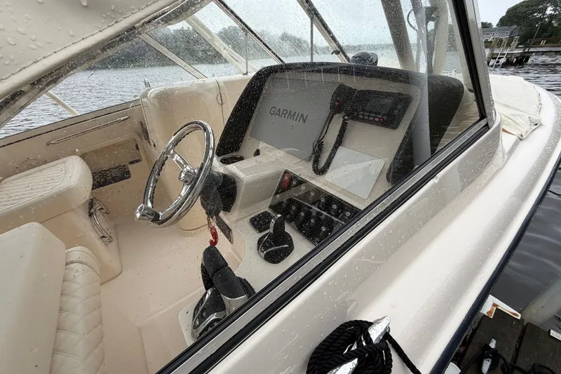 Slide: The Image of 2025 Grady-White Freedom 275 boat interior with Garmin navigation system, steering wheel, and controls. - 4