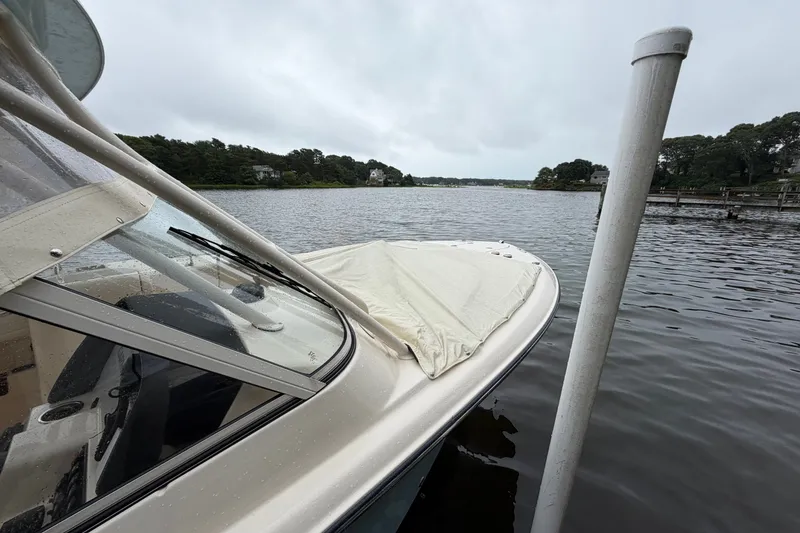 Slide: The Image of 2025 Grady-White Freedom 275 boat docked on a calm lake under cloudy skies. - 3