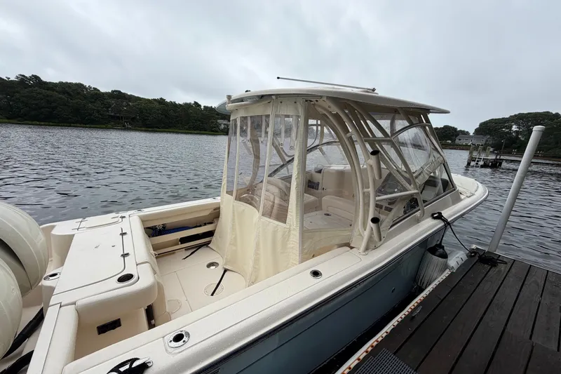 Slide: The Image of 2025 Grady-White Freedom 275 boat docked by a serene lake. - 2