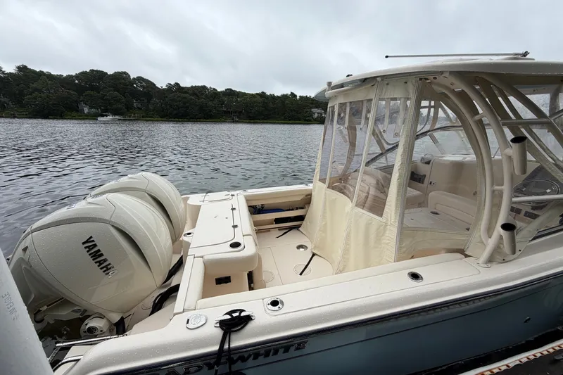 Slide: The Image of 2025 Grady-White Freedom 275 boat with Yamaha engines on a serene lake. - 1