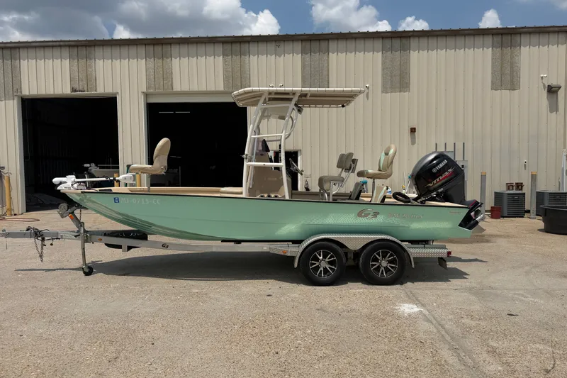 Slide: The Image of 2021 G3 Bay 20 DLX boat on trailer, parked outside a warehouse. - 2