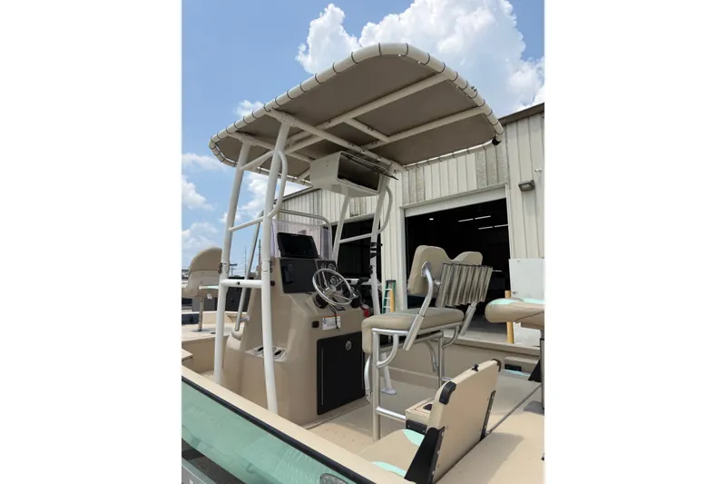 Slide: The Image of 2021 G3 Bay 20 DLX boat with canopy and seating, parked outdoors under a cloudy sky. - 15