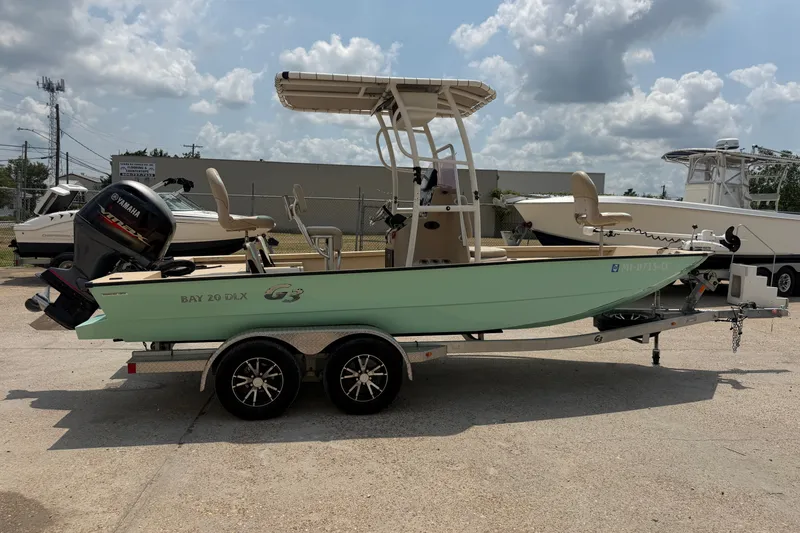 Slide: The Image of 2021 G3 Bay 20 DLX boat on trailer, featuring Yamaha outboard motor, parked outdoors. - 3