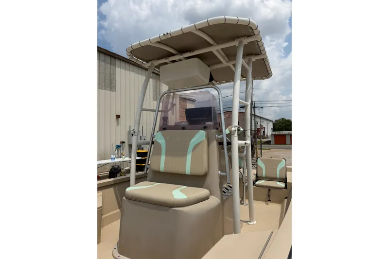 Slide: The Image of 2021 G3 Bay 20 DLX boat with beige seating and canopy, parked outdoors. - 12