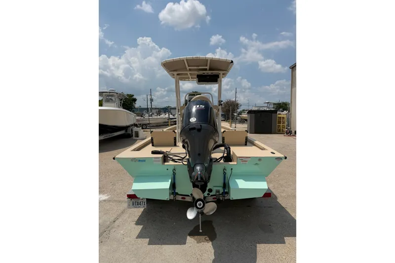 Slide: The Image of 2021 G3 Bay 20 DLX boat with outboard motor, parked outdoors under a cloudy sky. - 8