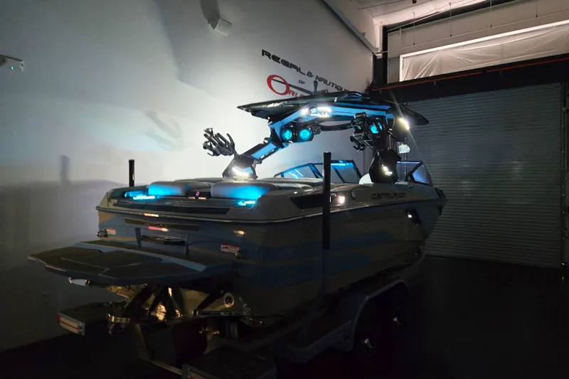 Slide: The Image of 2026 Centurion Ri230 boat with illuminated features in a dimly lit garage. - 18