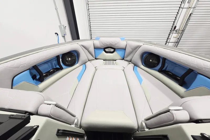 Slide: The Image of Interior of 2026 Centurion Ri230 boat with gray and blue seating, featuring built-in speakers. - 15