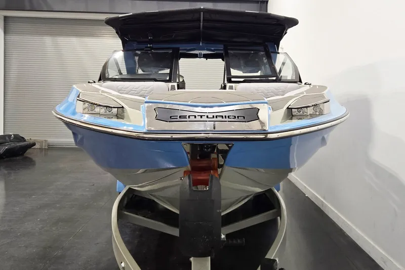 Slide: The Image of 2026 Centurion Ri230 boat in showroom, front view, sleek design, blue and white color. - 3