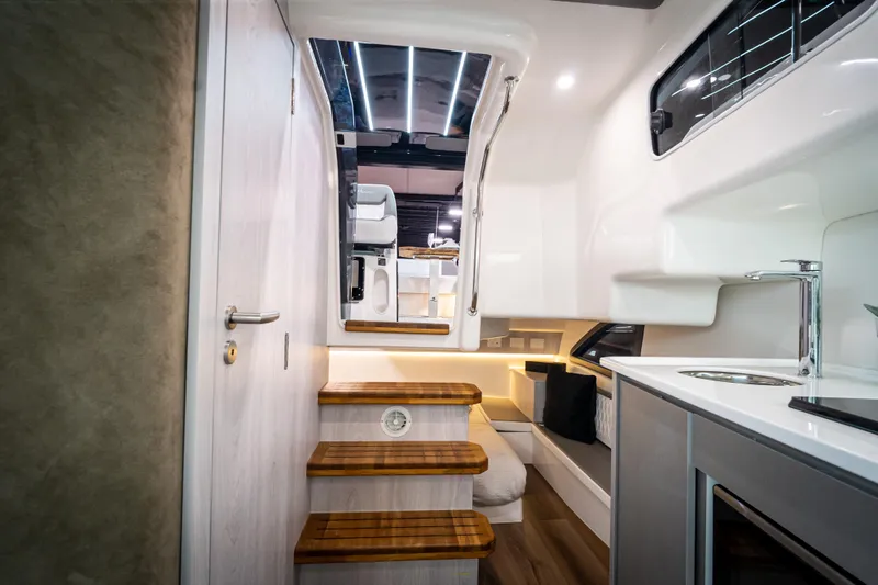 Slide: The Image of Interior of 2026 Hanover 347 yacht, featuring modern kitchen and wooden steps. - 16