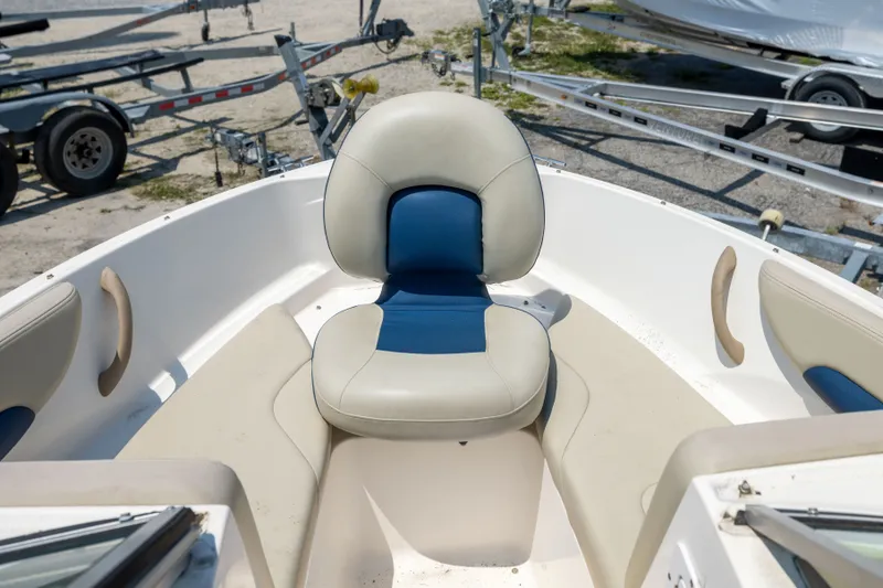 Slide: The Image of 2014 Chaparral 18 H2O Ski & Fish boat interior with seating and trailer in background. - 15