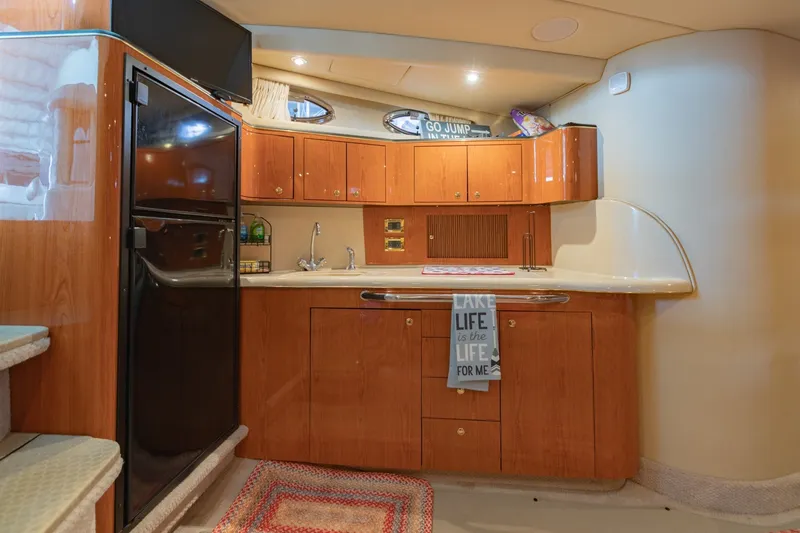 Slide: The Image of Luxurious kitchen interior of 2000 Sea Ray 410 Sundancer yacht with wood cabinetry. - 47