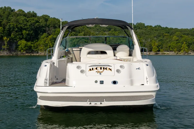 Slide: The Image of 2000 Sea Ray 410 Sundancer yacht on calm lake with lush green shoreline. - 10