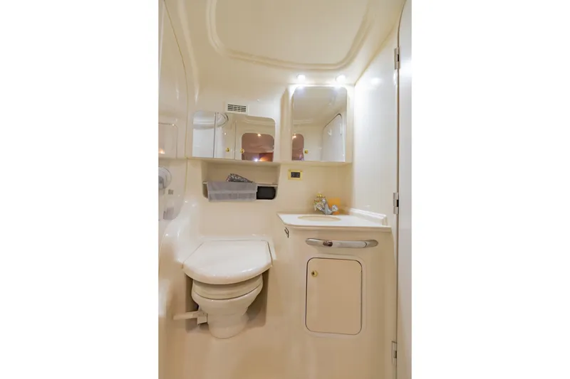 Slide: The Image of Compact bathroom in 2000 Sea Ray 410 Sundancer yacht, featuring toilet and vanity. - 54
