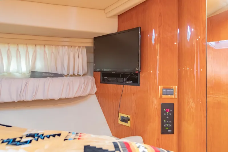 Slide: The Image of Luxurious cabin interior of 2000 Sea Ray 410 Sundancer with TV and wood paneling. - 59