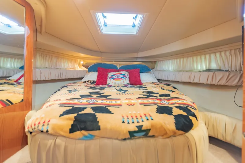 Slide: The Image of Cozy cabin interior of 2000 Sea Ray 410 Sundancer with patterned bedding and skylight. - 57