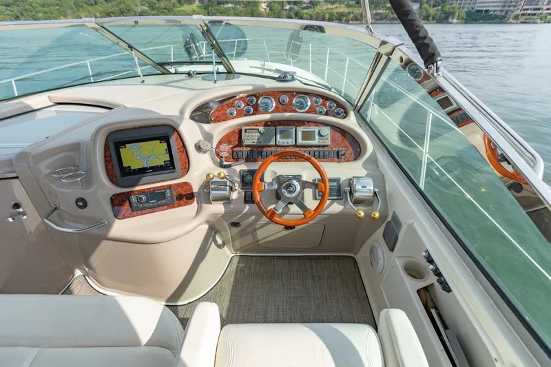 Slide: The Image of Cockpit of 2000 Sea Ray 410 Sundancer with navigation system and wooden steering wheel. - 38