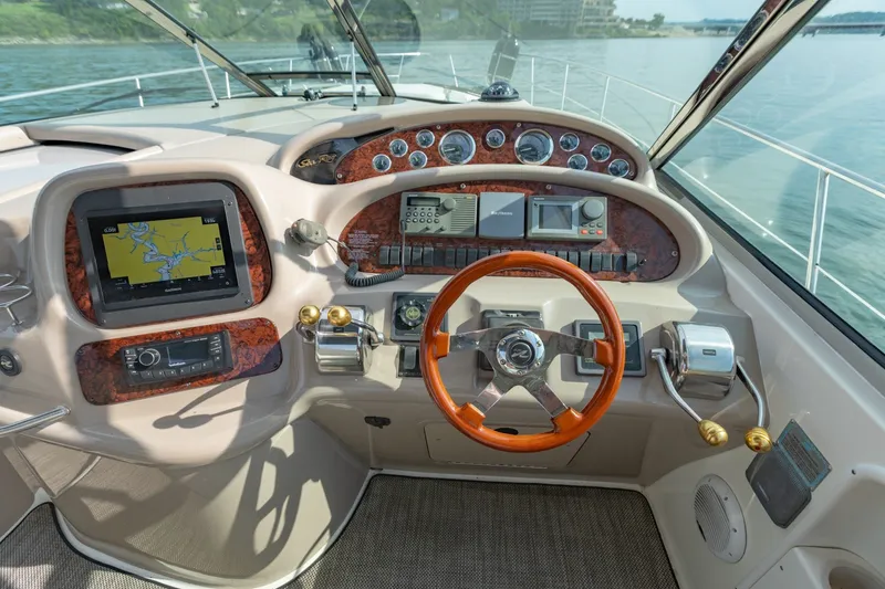Slide: The Image of Cockpit of 2000 Sea Ray 410 Sundancer with navigation system and wooden steering wheel. - 25