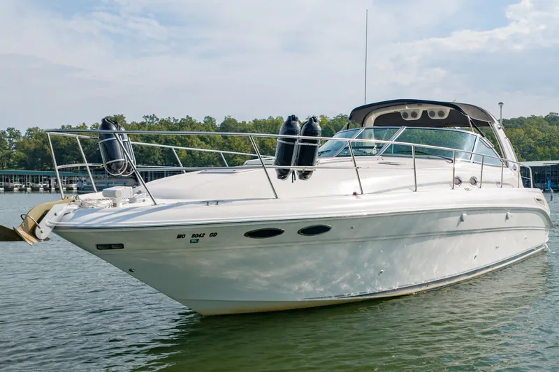 Slide: The Image of 2000 Sea Ray 410 Sundancer yacht on calm water, surrounded by lush greenery. - 5