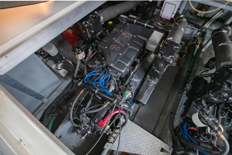 Slide: The Image of Engine compartment of a 2000 Sea Ray 410 Sundancer, showcasing mechanical components and wiring. - 60