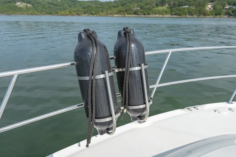 Slide: The Image of Fenders on a 2000 Sea Ray 410 Sundancer boat, floating on a serene lake. - 43