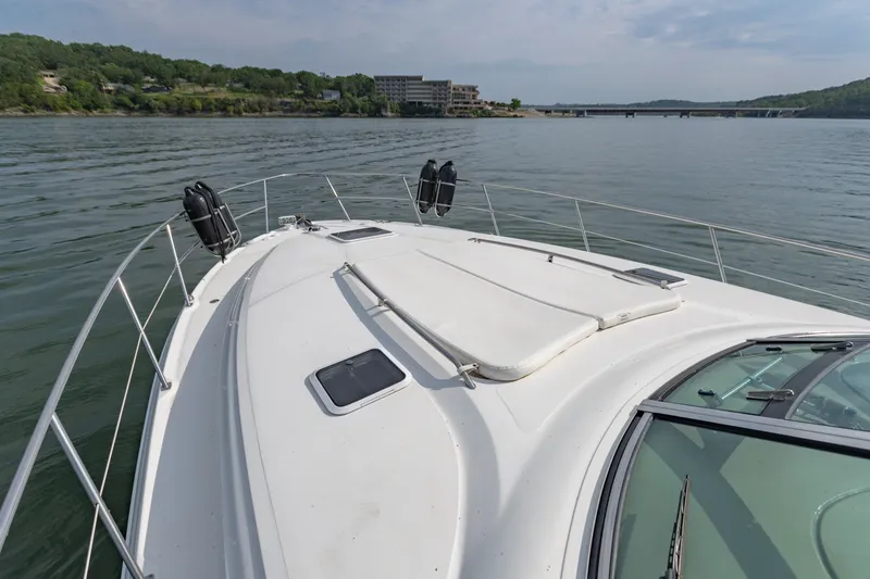 Slide: The Image of 2000 Sea Ray 410 Sundancer yacht on calm water, with scenic shoreline view. - 41