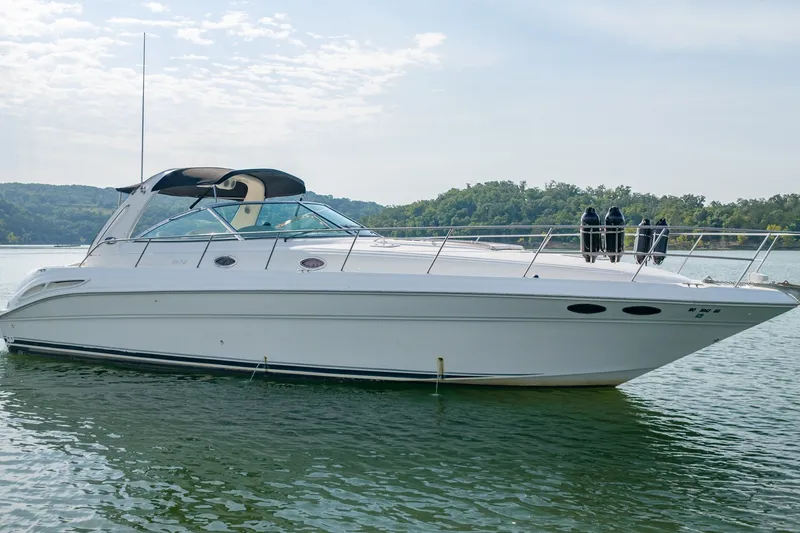Slide: The Image of 2000 Sea Ray 410 Sundancer yacht on calm water with scenic background. - 3