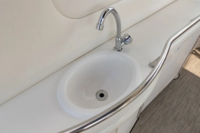 Slide: The Image of Sink and faucet on 2000 Sea Ray 410 Sundancer yacht, featuring sleek design and stainless steel railing. - 22