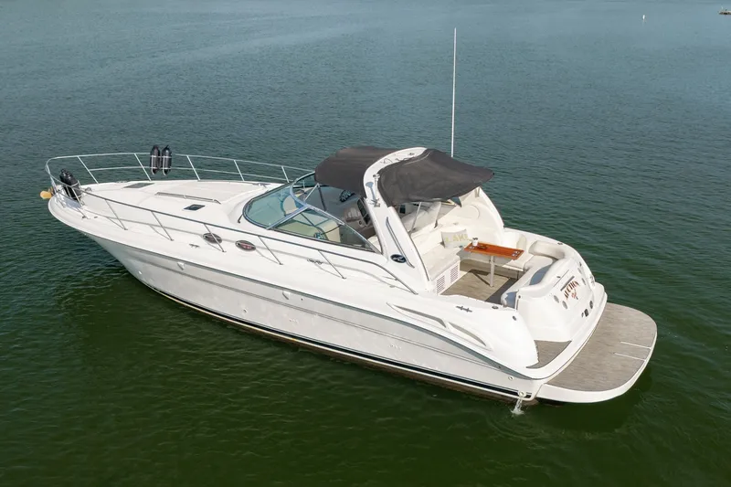 Slide: The Image of 2000 Sea Ray 410 Sundancer yacht on calm water, featuring sleek design and spacious deck. - 12