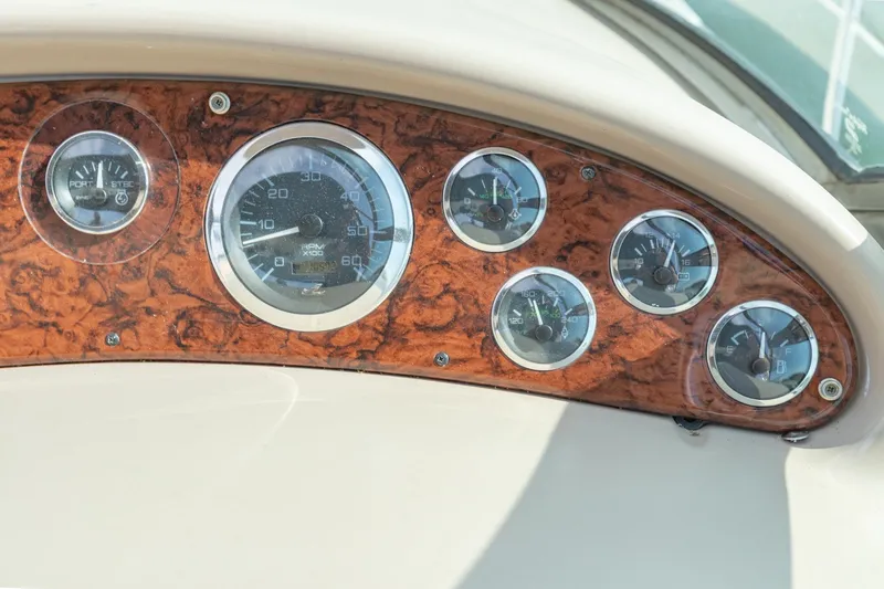Slide: The Image of Dashboard of a 2000 Sea Ray 410 Sundancer boat with wood paneling and gauges. - 28