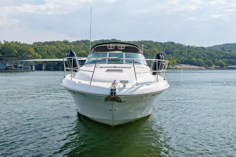 Slide: The Image of 2000 Sea Ray 410 Sundancer yacht on calm water with scenic forested background. - 4