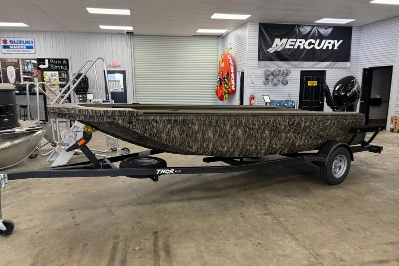 Slide: The Image of 2027 Thor 1754 Thunder Hammer boat on trailer in showroom, camo design, Suzuki engine. - 3