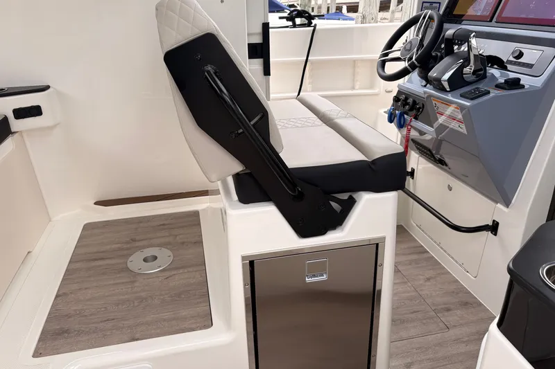 Slide: The Image of 2026 Navan C30 boat interior with modern helm, steering wheel, and cushioned seating. - 23