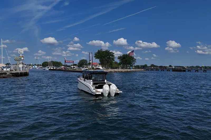 Slide: The Image of Navan C30 boat cruising in a marina under a clear blue sky, 2026 model. - 3