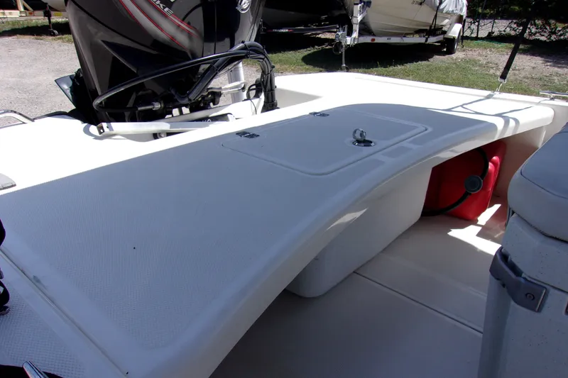 Slide: The Image of 2019 Mako Pro Skiff 17 CC boat interior with storage compartment and outboard motor. - 7