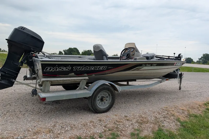 Slide: The Image of 1999 Tracker Pro Team 175 bass boat on trailer, parked on gravel road. - 7