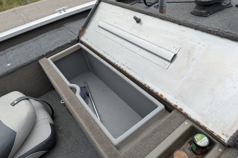Slide: The Image of 1999 Tracker Pro Team 175 boat storage compartment with open lid and nearby seat. - 17