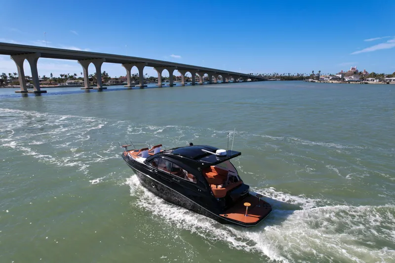Slide: The Image of Luxury Hanover 355 yacht cruising under a bridge, 2026 model, in sunny waters. - 1