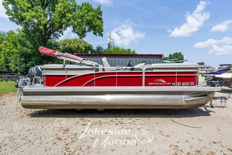 Slide: The Image of 2021 Bennington SV 22 Quad Bench pontoon boat with red exterior, parked outdoors. - 2