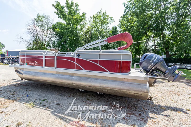 Slide: The Image of 2021 Bennington SV 22 Quad Bench pontoon boat with Yamaha motor, parked outdoors. - 7