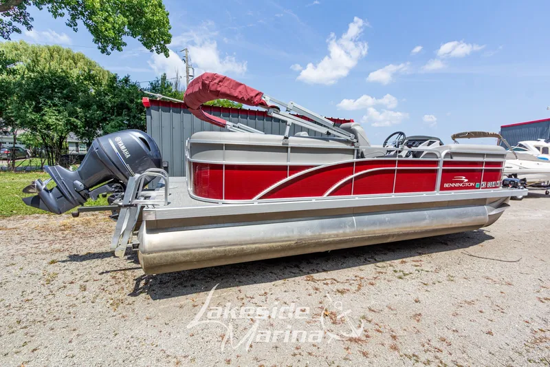 Slide: The Image of 2021 Bennington SV 22 Quad Bench pontoon boat with Yamaha motor, parked outdoors. - 3