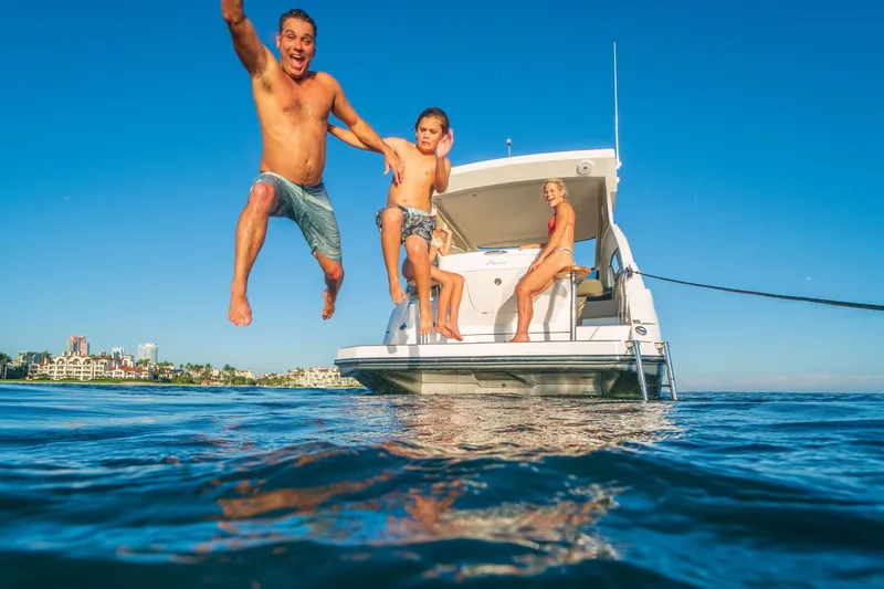 Slide: The Image of Family enjoying a sunny day on a 2026 Hanover 375 yacht, jumping into the ocean. - 14