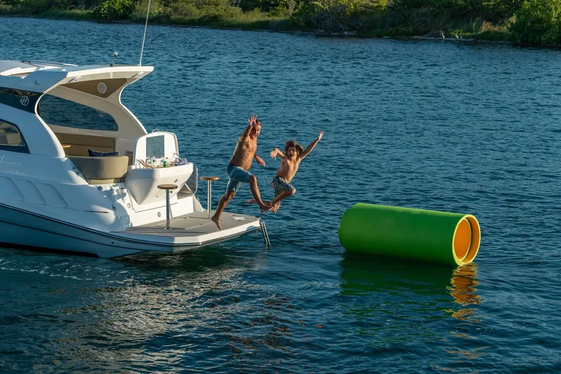 Slide: The Image of Two people jumping off a Hanover 375 yacht into the water, 2026 model. - 78