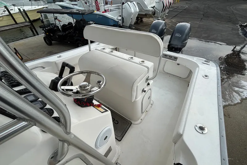 Slide: The Image of 2006 Cape Horn 24 boat interior with steering wheel and dual engines at dock. - 26