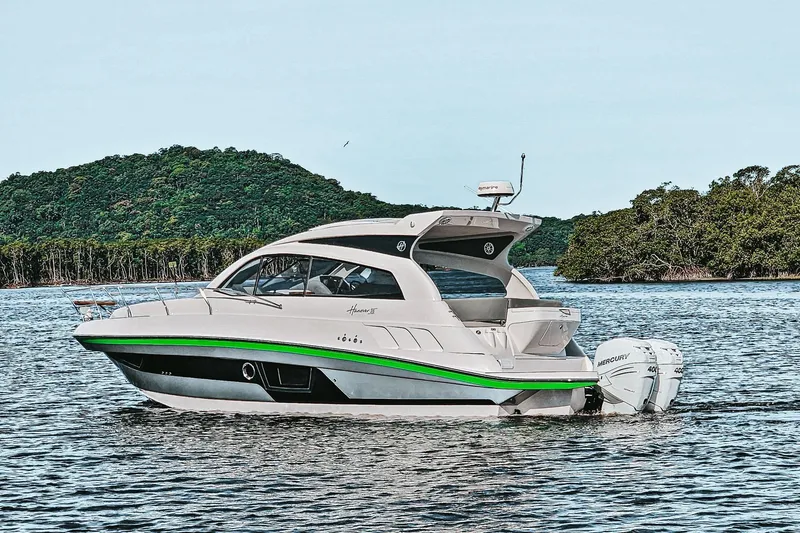 Slide: The Image of 2026 Hanover 375 boat on water with lush green island backdrop. - 2