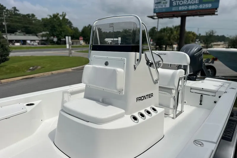 Slide: The Image of 2027 Frontier 2104 boat with center console and seating, parked outdoors. - 15