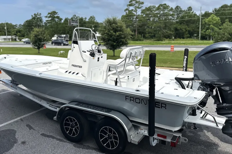 Slide: The Image of 2027 Frontier 2104 boat on trailer with Yamaha engine, parked outdoors. - 22