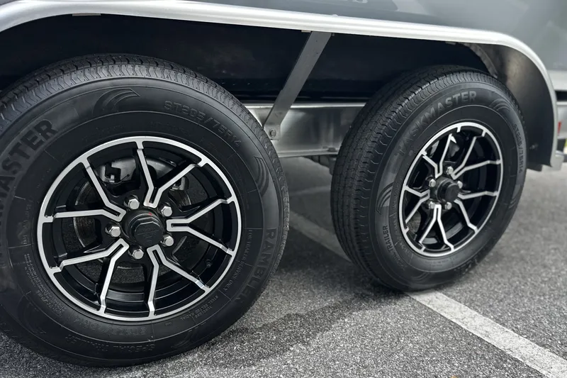 Slide: The Image of Close-up of Frontier 2104 2027 model wheels with black alloy rims on asphalt. - 20