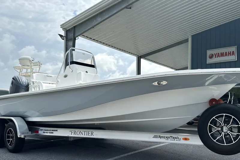 Slide: The Image of 2027 Frontier 2104 boat on trailer under canopy, Yamaha sign visible. - 28
