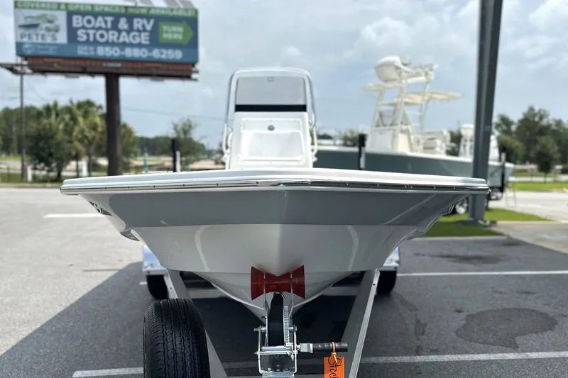 Slide: The Image of Front view of a 2027 Frontier 2104 boat on a trailer in a parking lot. - 30